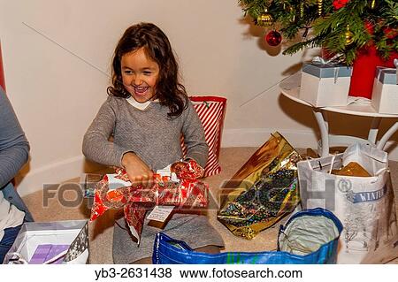 A Mixed Race Child Opening Her Christmas Presents On Christmas Day, Brighton, Sussex, UK. View Large Photo Image Stock Photo - A Mixed Race Child Opening Her Christmas Presents On Christmas Day, Brighton, Sussex, UK.. Fotosearch