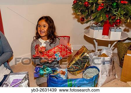 A Mixed Race Child Opening Her Christmas Presents On Christmas Day, Brighton, Sussex, UK. View Large Photo Image Stock Photo - A Mixed Race Child Opening Her Christmas Presents On Christmas Day, Brighton, Sussex, UK.. Fotosearch