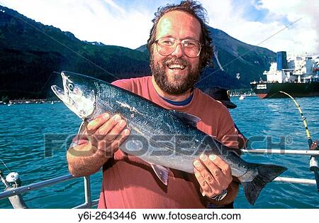 Stock Photograph - Angler with salmon Alaska USA.. Fotosearch