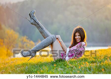 Stock Photography - Attractive woman happy playful on the grass. Fotosearch