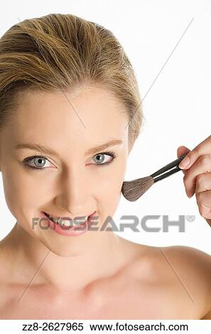 Beautiful young woman applying blusher to her face. View Large Photo Image Stock Photography - Beautiful young woman applying blusher to her face.. Fotosearch