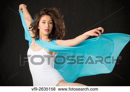 Beautiful young woman dancer in light blue cape and white leotard, with half length, spinning turn against black background. View Large Photo Image Stock Photo - Beautiful young woman dancer in light blue cape and white leotard, with half length, spinning turn against black background.. Fotosearch