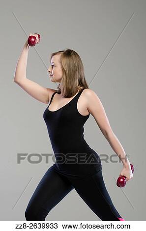 Beautiful young woman working out with dubbells. View Large Photo Image Stock Image - Beautiful young woman working out with dubbells.. Fotosearch