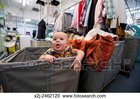 Broomfield, Colorado - 10 months old baby, enjoys a makeshift playpen in a clothes bin at Lionheart Cleaners. View Large Photo Image Stock Image - Broomfield, Colorado - 10 months old baby, enjoys a makeshift playpen in a clothes bin at Lionheart Cleaners.. Fotosearch