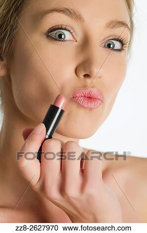 Close up of a young woman applying lipstick. View Large Photo Image Stock Image - Close up of a young woman applying lipstick.. Fotosearch