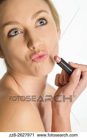 Close up of a young woman applying lipstick. View Large Photo Image Stock Image - Close up of a young woman applying lipstick.. Fotosearch
