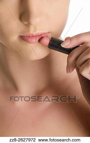 Close up of a young woman applying lipstick. View Large Photo Image Stock Image - Close up of a young woman applying lipstick.. Fotosearch