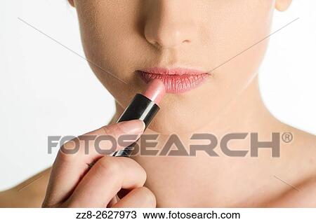 Close up of a young woman applying lipstick. View Large Photo Image Stock Image - Close up of a young woman applying lipstick.. Fotosearch