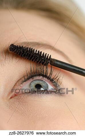 Close up of a young woman applying mascara to eyelashes. View Large Photo Image Stock Photograph - Close up of a young woman applying mascara to eyelashes.. Fotosearch