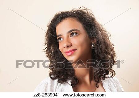 Stock Image - Daydreaming teenage girl looking up smiling.. Fotosearch