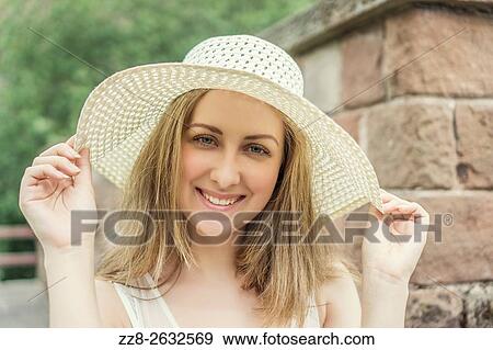 Happy beautiful woman holding her hat outdoors. View Large Photo Image Stock Photo - Happy beautiful woman holding her hat outdoors.. Fotosearch