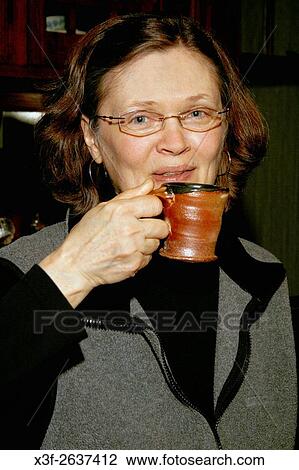 Happy host age 59 relaxing with freshly brewed cup of coffee. St Paul Minnesota USA. View Large Photo Image Stock Image - Happy host age 59 relaxing with freshly brewed cup of coffee. St Paul Minnesota USA.. Fotosearch