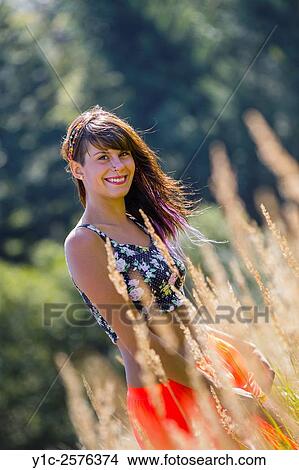 Picture - Happy in grassfield young woman. Fotosearch