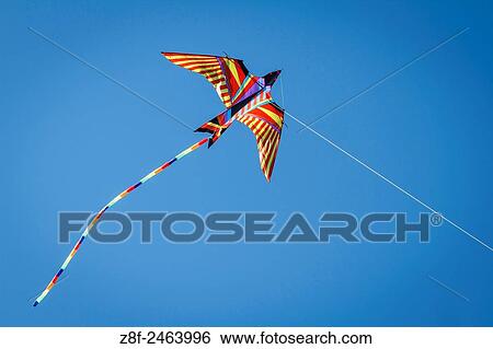 Stock Photograph - Kite flying in blue sky.. Fotosearch