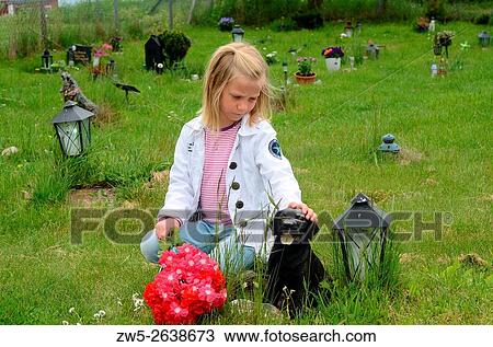 Stock Image - Little girl at her pets grave in Ystad, Sweden.. Fotosearch