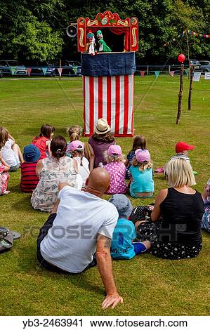 Local Children Watch A Traditional Punch & Judy Show At The Annual Nutley Village Fete, Nutley, Sussex, UK. View Large Photo Image Stock Image - Local Children Watch A Traditional Punch & Judy Show At The Annual Nutley Village Fete, Nutley, Sussex, UK.. Fotosearch