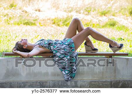 Lying on narrow wall young woman in long dress View Large Photo Image Stock Photo - Lying on narrow wall young woman in long dress. Fotosearch