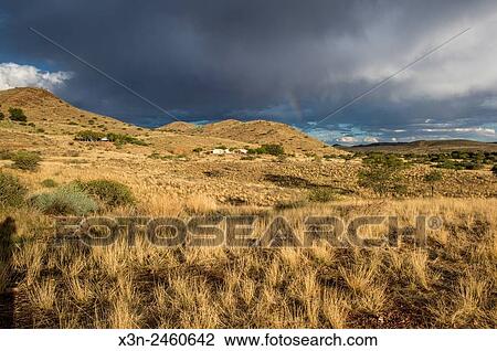 Namibia, Africa - Rainbow coming down from dark clouds in the distance over a dry landscape. View Large Photo Image Stock Image - Namibia, Africa - Rainbow coming down from dark clouds in the distance over a dry landscape.. Fotosearch