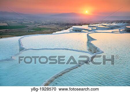 Stock Image - Pamukkale, sunset view of the limestone terraces, Pamukkale near Denizli, Turkey. Fotosearch