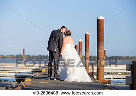 Portrait of a bride and groom on their wedding day at a yacht club marina in Oregon. View Large Photo Image Stock Photo - Portrait of a bride and groom on their wedding day at a yacht club marina in Oregon.. Fotosearch