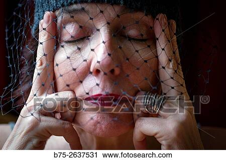 Portrait of a mature woman with a thoughtful expression and relaxation, with eyes closed, fingers at her temples and a veil covering her face. View Large Photo Image Stock Image - Portrait of a mature woman with a thoughtful expression and relaxation, with eyes closed, fingers at her temples and a veil covering her face.. Fotosearch
