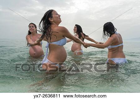 Stock Image - Pregnant women at the beach. Tarifa, Costa de la Luz, Cadiz, Andalusia, Southern Spain, Europe.. Fotosearch