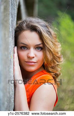 Stock Image - Pretty teen girl portrait near wall wavy hair. Fotosearch