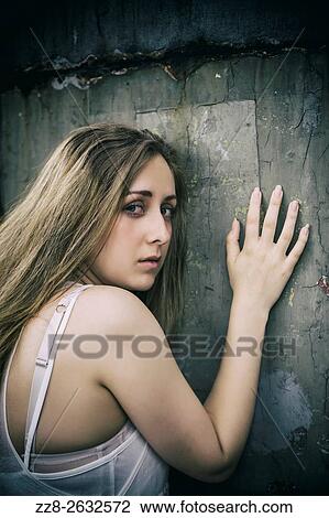Scared young woman leaning against the wall. View Large Photo Image Stock Image - Scared young woman leaning against the wall.. Fotosearch