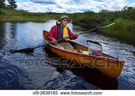 Senior man with sunglasses and hat solo paddling a small canoe on a tranquil Moose River in Old Forge, New York. View Large Photo Image Stock Image - Senior man with sunglasses and hat solo paddling a small canoe on a tranquil Moose River in Old Forge, New York.. Fotosearch