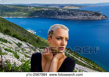 Picture - Short-haired young woman head-and-shoulders outdoors. Fotosearch