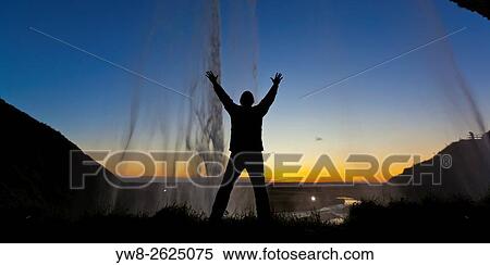 Silhouette of man behind Seljalandsfoss Waterfall, Iceland. View Large Photo Image Stock Photography - Silhouette of man behind Seljalandsfoss Waterfall, Iceland.. Fotosearch