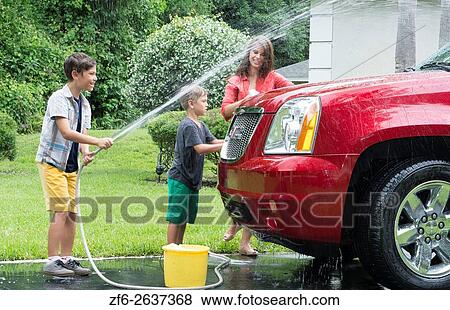 Single mother washing car at home with her two children in driveway with hose MR-11, MR-12, MR-13 Model Released. View Large Photo Image Stock Photo - Single mother washing car at home with her two children in driveway with hose MR-11, MR-12, MR-13 Model Released.. Fotosearch