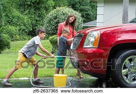 Single mother washing car at home with her two children in driveway with hose MR-11, MR-12, MR-13 Model Released. View Large Photo Image Stock Photography - Single mother washing car at home with her two children in driveway with hose MR-11, MR-12, MR-13 Model Released.. Fotosearch
