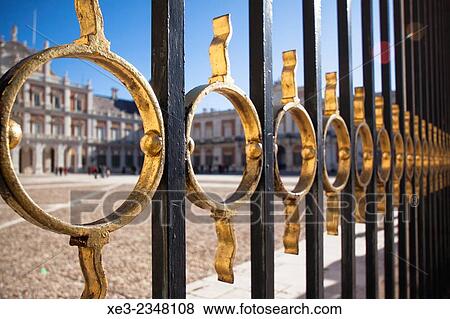 Stock Photo - Spain, Madrid Province, Aranjuez, View of Royal Palace through architectural details of gate. Fotosearch