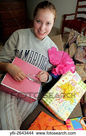Picture - Teenage American girl opening birthday presents.. Fotosearch