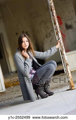 Stock Photo - Teenager girl squatting outdoors. Fotosearch