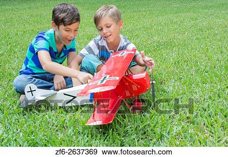 Two young boys playing with a model plane German Fokker DII from WWI in the yard at home MR-12 MR- 13 Model released. View Large Photo Image Stock Photo - Two young boys playing with a model plane German Fokker DII from WWI in the yard at home MR-12 MR- 13 Model released.. Fotosearch