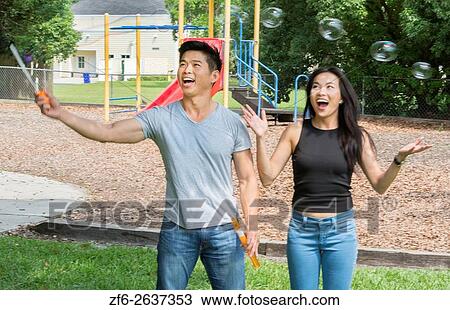 Vietnamese-American couple dating at playground blowing bubbles and having fun MR-6 MR-8 Model released. View Large Photo Image Stock Image - Vietnamese-American couple dating at playground blowing bubbles and having fun MR-6 MR-8 Model released.. Fotosearch