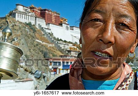 Woman spins prayer wheel by Potala Palace 17th century traditional Dalai Lama winter residence Lhasa Tibet View Large Photo Image Stock Photo - Woman spins prayer wheel by Potala Palace 17th century traditional Dalai Lama winter residence Lhasa Tibet. Fotosearch
