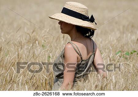 Woman with a straw hat standing in the wheat field in Ticino, Switzerland. View Large Photo Image Stock Photo - Woman with a straw hat standing in the wheat field in Ticino, Switzerland.. Fotosearch