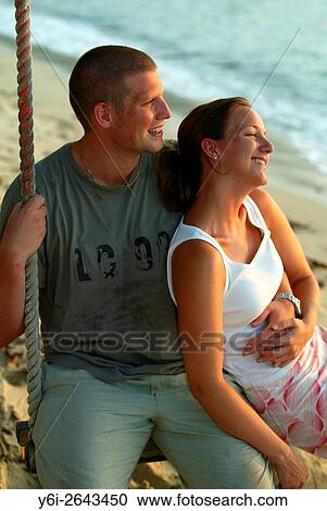 Young couple embrace on swing Teluk Nipah beach Pulau Pangkor island Malaysia. View Large Photo Image Stock Image - Young couple embrace on swing Teluk Nipah beach Pulau Pangkor island Malaysia.. Fotosearch