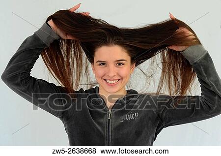 Young smiling woman, 25 years old, brunette, holding up her long hair. View Large Photo Image Stock Photo - Young smiling woman, 25 years old, brunette, holding up her long hair.. Fotosearch
