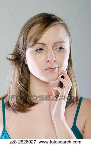 Young woman with a worried expression looking away View Large Photo Image Stock Photo - Young woman with a worried expression looking away. Fotosearch