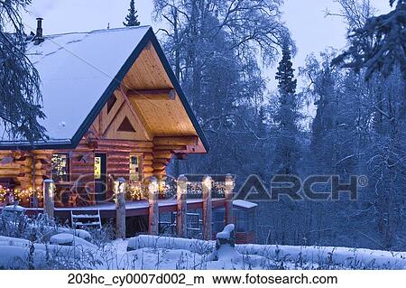 Log Cabin In The Woods Decorated With Christmas Lights At Twilight