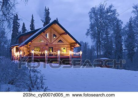 Log Cabin In The Woods Decorated With Christmas Lights At Twilight