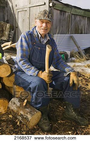 Picture of Elder Native Yupik Man Holding Axe Sits On Log Pile Near ...