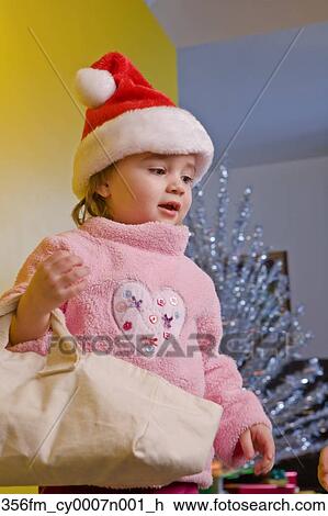 Young 2 year old girl wearing Santa hat 
