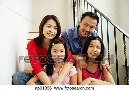 Stock Image - Family of four sitting on stairs, looking at camera, family portrait. Fotosearch - Search Stock Photography, Poster Photos, Pictures, and Photo Clip Art