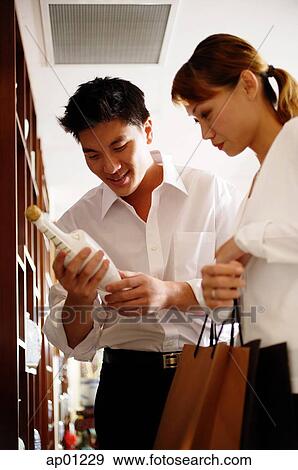 Couple in antique shop, looking at bottle View Large Photo Image Stock Photograph - Couple in antique shop, looking at bottle. Fotosearch - Search Stock Photography, Posters, Pictures, and Photo Clipart Images