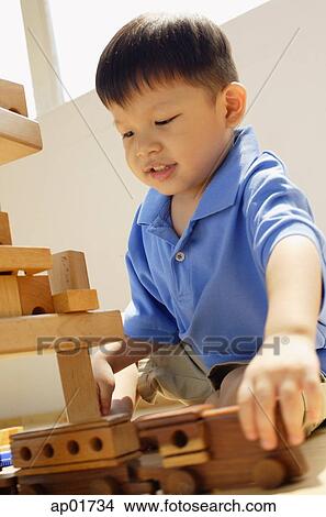 Boy playing with toy train View Large Photo Image Picture - Boy playing with toy train. Fotosearch